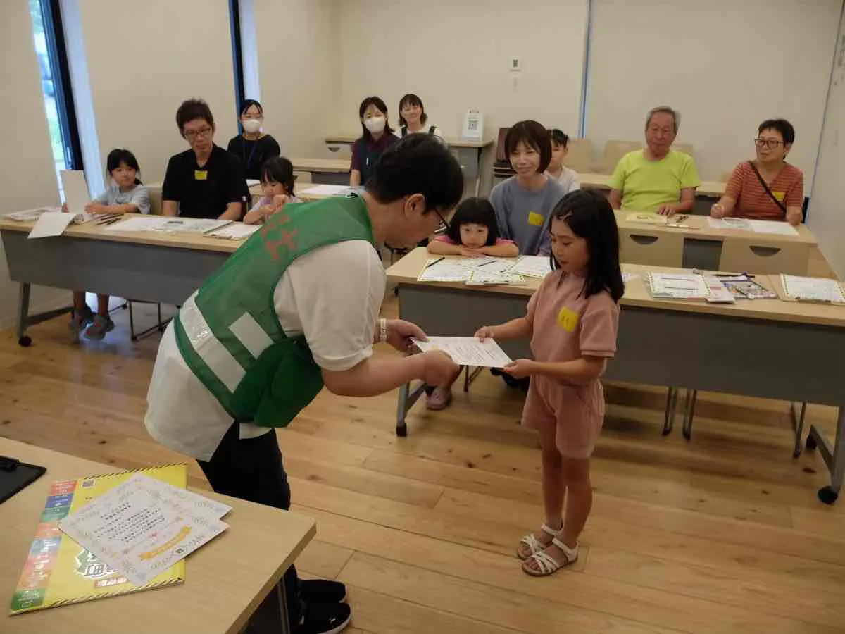 防災探検隊の活動で子どもに修了証を手渡すそなえラボ主催者
