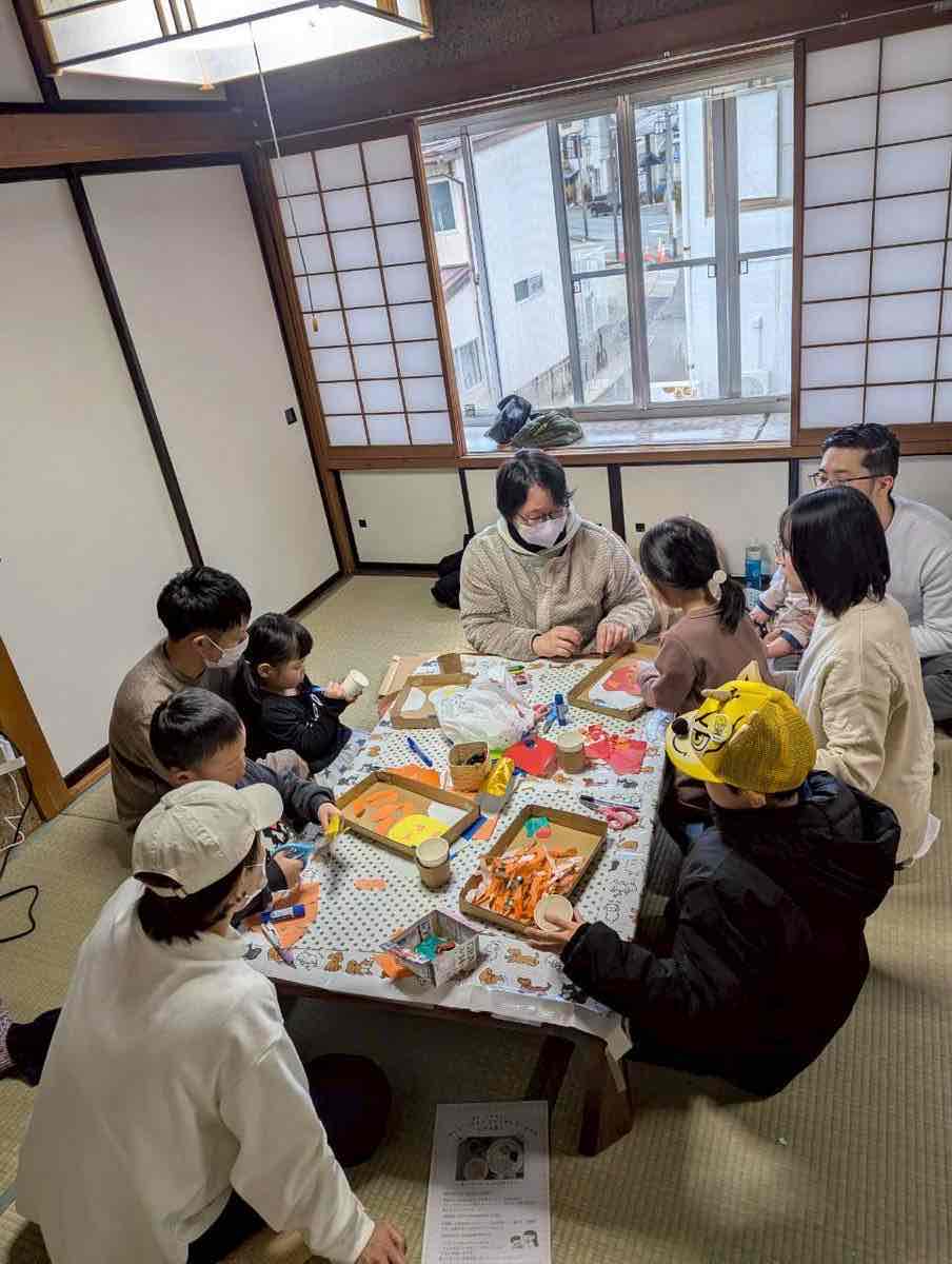 テーブルを囲み、段ボール工作に取り組む親子