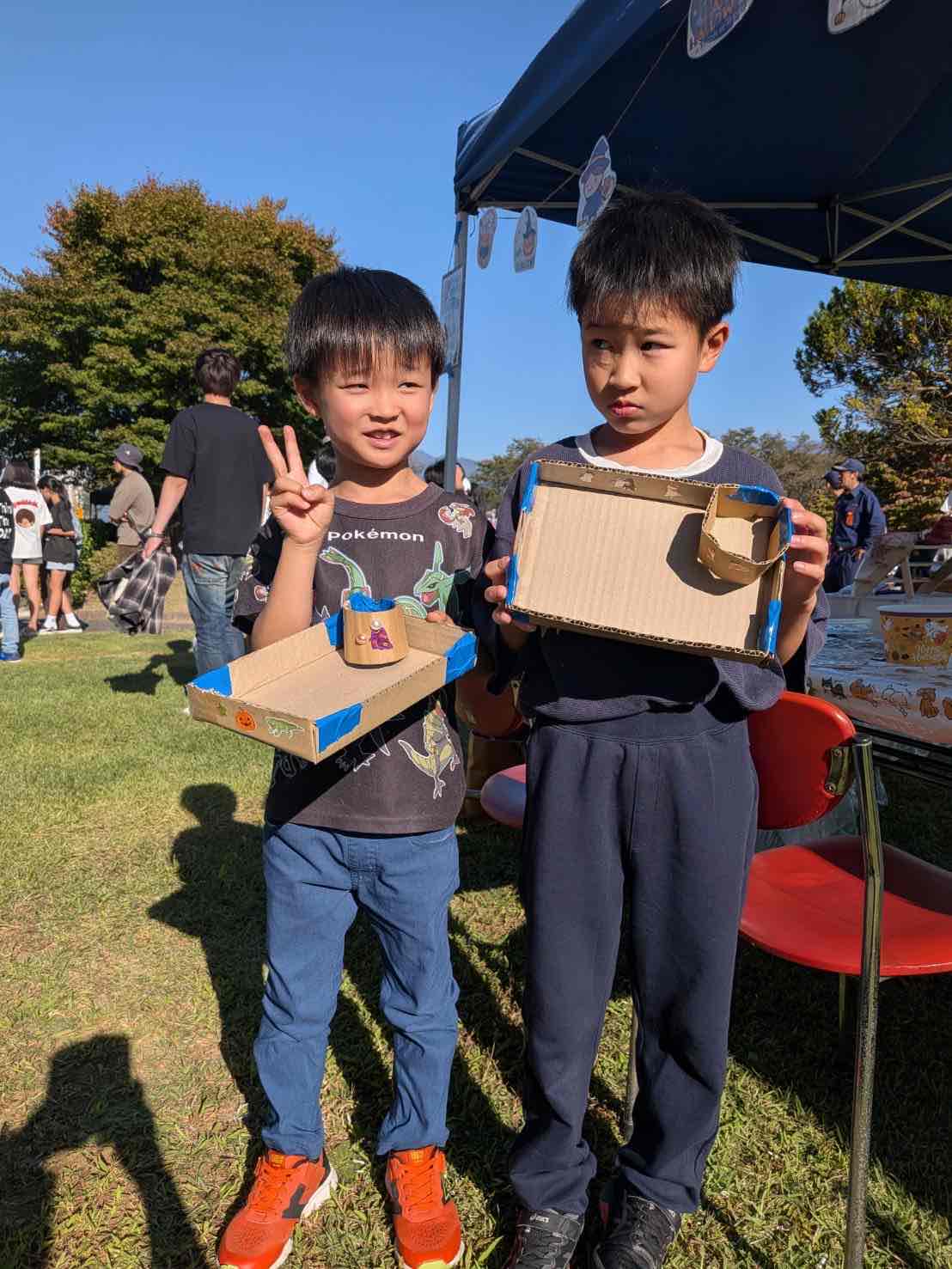 作った段ボール食器を手にする子どもたち